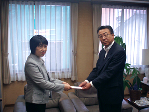 自治労大阪からの支援金を手渡す蜂谷委員長の写真