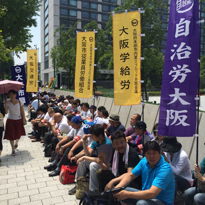 灼熱の太陽が照りつけるなか、大阪からの参加者は座り込みで法案の反対をアピールした